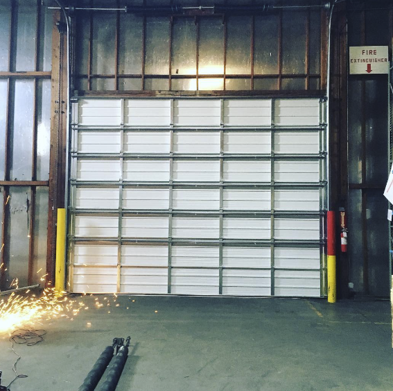Warehouse metal door with visible fire extinguisher.